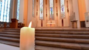 Blick auf eine brennende Kerze in der Jenaer Stadtkirche St. Michael