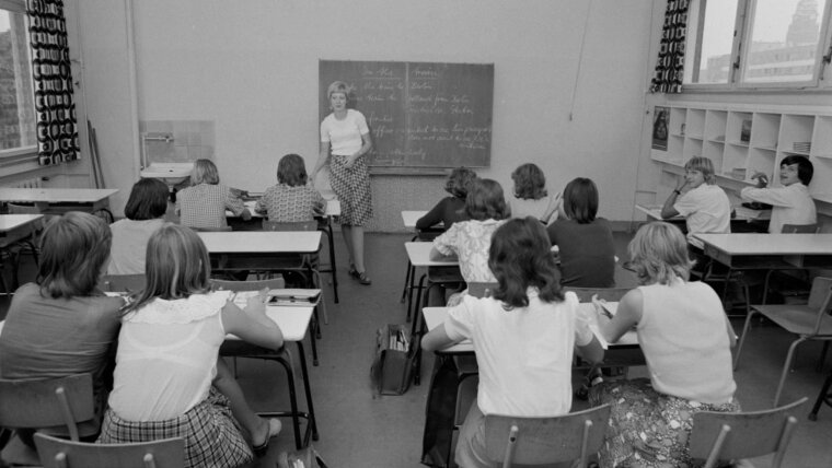 DDR Klassenzimmer mit Lehrerin vor der Tafel und Schüler